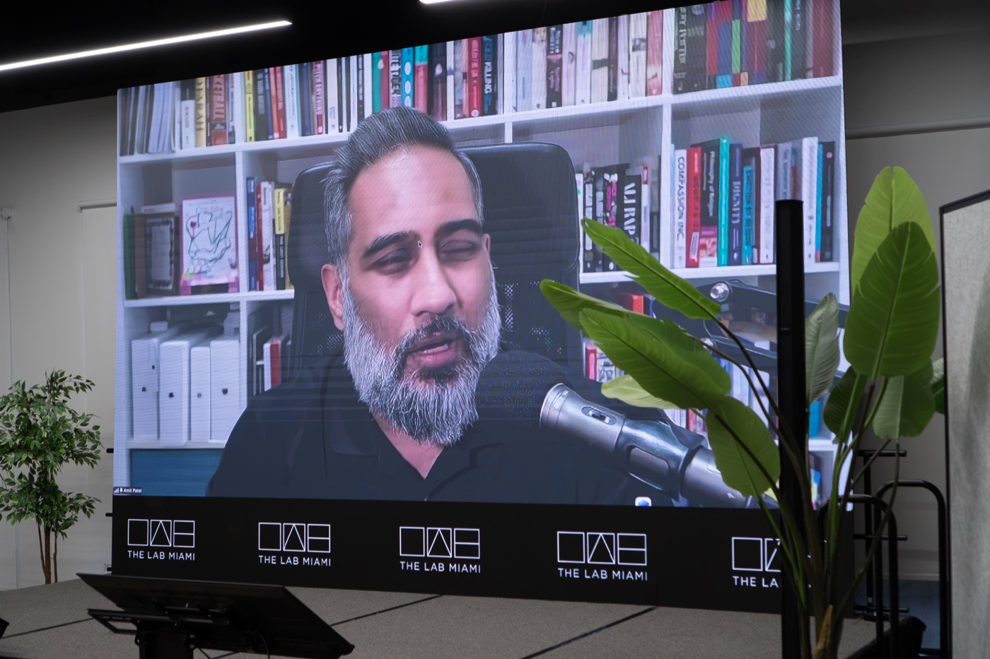 Amit Patel on the main screen, speaking from London